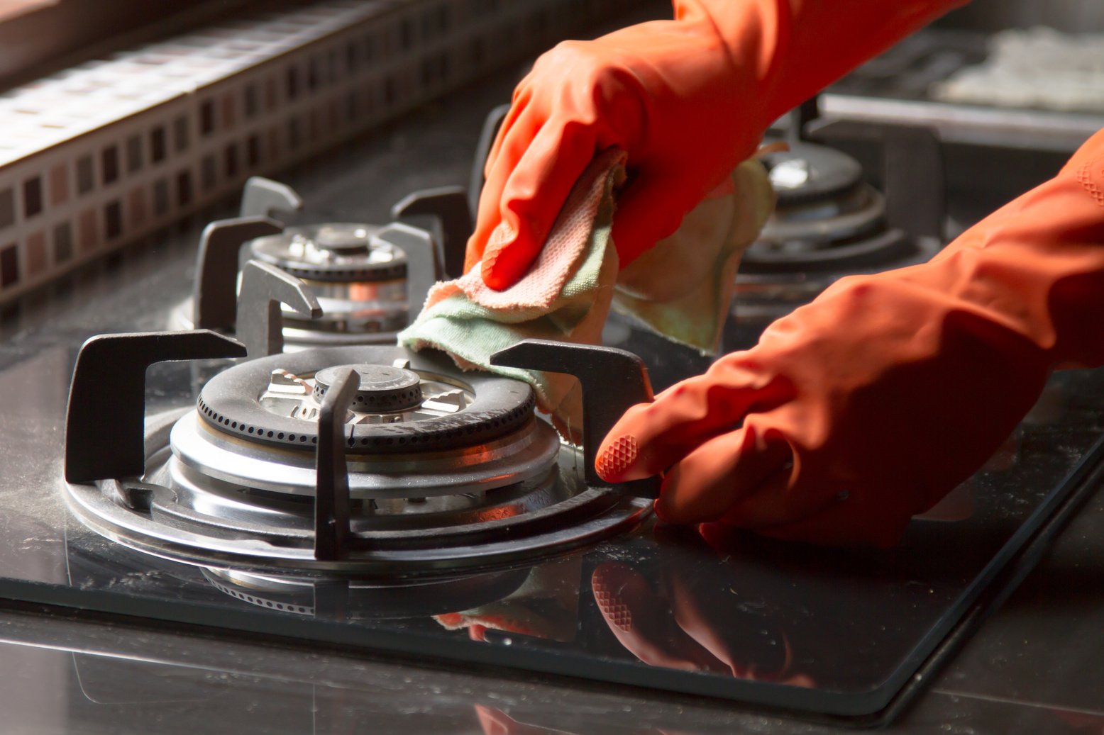 Cleaning gas stove at kitchen